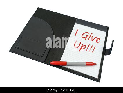 Horizontal shot of a junior legal pad with I GIVE UP written in red and a red marker.  White background. Angled. Stock Photo