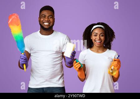 Ready For Housework. Positive Black Couple Posing With Cleaning Tools In Hands Stock Photo