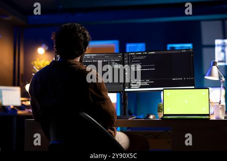Programmer using green screen laptop to implement security measures, protecting company systems and data. IT worker writing, testing and debugging code for software applications on chroma key notebook Stock Photo