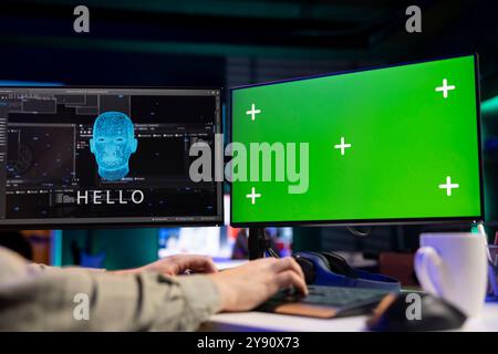 Software programmer watching AI on isolated screen PC gaining consciousness. Computer engineer seeing artificial intelligence talking on chroma key monitor, sitting at desk Stock Photo