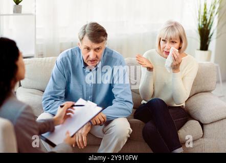 Senior couple in therapy working out problems with counselor Stock Photo