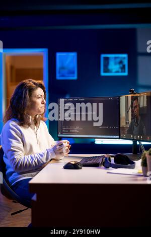 IT admin working from home in videocall with african american coworker, testing programs and systems. Programmer checking code with colleague in online teleconference, sitting at desk in apartment Stock Photo