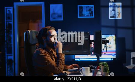 Software engineer doing programming using augmented reality visualization during remote job shift in home office. IT admin working on computer, looking at AR hologram, camera A Stock Photo