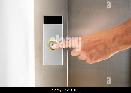 A man's finger presses the elevator button at building Stock Photo