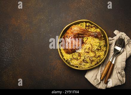 Delicious Indian dish Biryani chicken with basmati rice in metal brass old bowl on table dark rustic stone background. Traditional non-vegetarian food Stock Photo