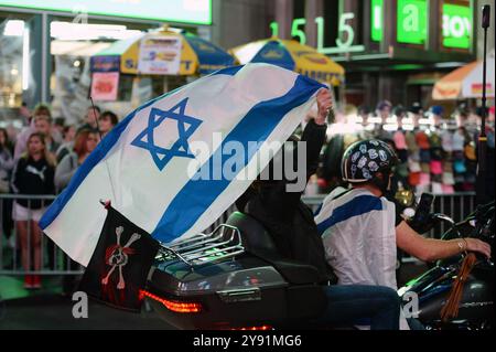 New York, USA. 31st Dec, 2011. People riding motorcycle with American-Israel flag ride past pro-Israeli protestors gathered in Times Square as they mark one year of the war between Hamas and Israel, New York, NY, October 7, 2024. (Photo by Anthony Behar/Sipa USA) Credit: Sipa USA/Alamy Live News Stock Photo