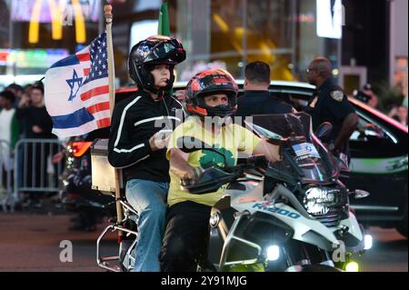 New York, USA. 31st Dec, 2011. People riding motorcycle with American-Israel flag ride past pro-Israeli protestors gathered in Times Square as they mark one year of the war between Hamas and Israel, New York, NY, October 7, 2024. (Photo by Anthony Behar/Sipa USA) Credit: Sipa USA/Alamy Live News Stock Photo