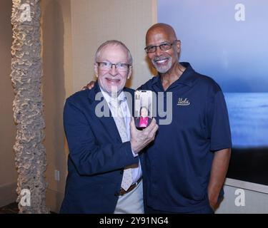 Los Angeles, California, USA. 3rd October, 2024. Director/filmmaker Harrison Engle holds cell phone with artist Chun Liu attending by videoconference, and artist Michael Warren at the Luskin Gallery Exhibition at UCLA in Los Angeles, California. Credit: Sheri Determan Stock Photo