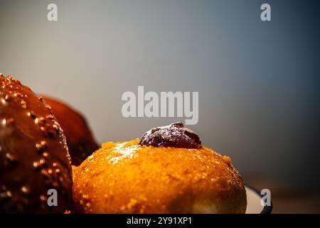 Donuts: jam donuts, donut with chocolate powder spread on top, donut covered with crispy chocolate and nuts. Stock Photo