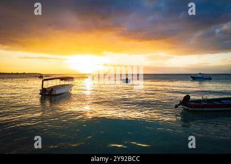 Beautiful drone view of fishing boats moored to buoys off the shore of Grand Baie, Mauritius, with a beautiful sunset in the background Stock Photo
