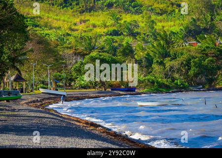 Beautiful view of the Indian Ocean breaking on the pebble beach at Grand Sable, Mauritius, on a very windy day, with a lone fisherman trying his luck Stock Photo