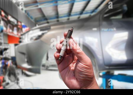 Dirty and damaged spark plugs , close up of old spark plugs of car combustion engine in the hands of car mechanic , Car repair concept Stock Photo