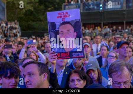 New York, United States. 07th Oct, 2024. A member of the audience holds a photo of hostage held in Gaza at an 'October 7: One Year Later' commemoration to mark the anniversary of the Hamas-led attack in Israel at the Summer Stage in Central Park on October 07, 2024 in New York City. On October 7, 2023, thousands of Hamas-Led Palestinians swarmed out from the Gaza strip into Israel, murdered 1,139 people and kidnapped approximately 250 Israelis and foreigners with nearly 100 still unaccounted for. Credit: SOPA Images Limited/Alamy Live News Stock Photo