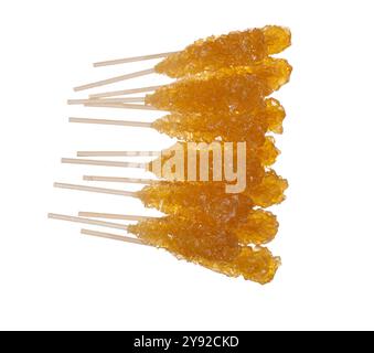 Golden rock candy sticks on white background, close-up of crystallized sugar Stock Photo