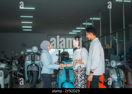 young woman shakes hands with a saleswoman in a hijab at showroom Stock Photo