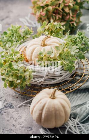 Table decoration with wreath and white pumpkins on kitchen table for Thanksgiving and Halloween Stock Photo