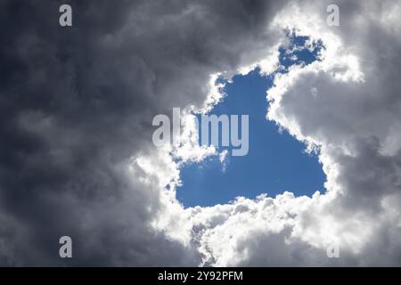Hole in the dark stormy clouds, visible blue sky and sunshine. Corfu, Greece. Stock Photo