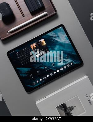 LONDON - OCTOBER 08, 2024: Apple iPad Pro on desk with pencil stylus overhead top view Stock Photo