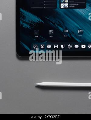 LONDON - OCTOBER 08, 2024: Apple iPad Pro on desk with pencil stylus overhead top view Stock Photo