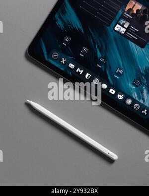 LONDON - OCTOBER 08, 2024: Apple iPad Pro on desk with pencil stylus overhead top view Stock Photo