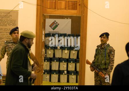 Indian paramilitary soldiers stand on guard outside a strong room where Electronic Voting Machines (EVM) are kept as election officials count votes at a polling counting centre in Srinagar. With multi-tier security in place, the countdown begins for the Jammu and Kashmir assembly election results 2024. The Union Territory is set to have an elected government since June 2018, when the Bharatiya Janata Party (BJP) broke its alliance with the People's Democratic Party (PDP), forcing Mehbooba Mufti to resign as chief minister. Eight months later, on August 5, 2019, the Indian Prime Minister Narend Stock Photo