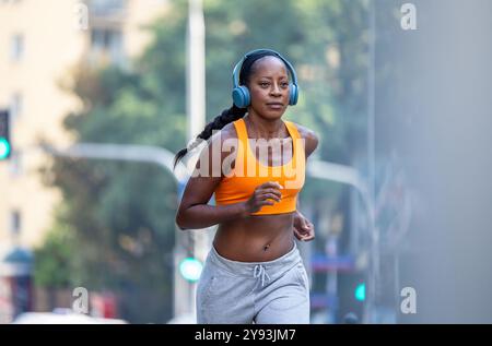 Woman running in the city on a sunny day Stock Photo