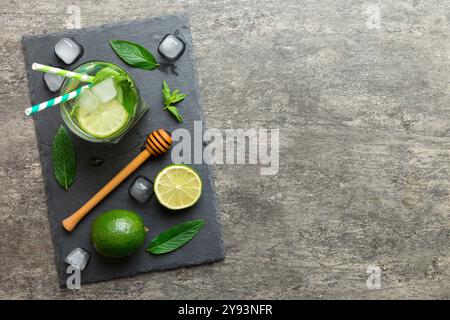 Caipirinha, Mojito cocktail, vodka or soda drink with lime, mint and straw on table background. Refreshing beverage with mint and lime in glass top vi Stock Photo