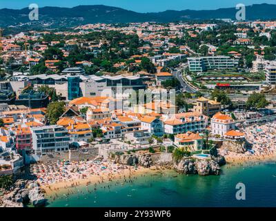 Aerial view of Cascais beaches and colourful rooftops of coastal town under bright sunlight with Sintra mountains in the background, Cascais, Portugal Stock Photo