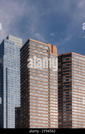 Close-up view of modern skyscrapers with reflective glass windows against a clear blue sky in New York City. The buildings' geometric lines highlight Stock Photo