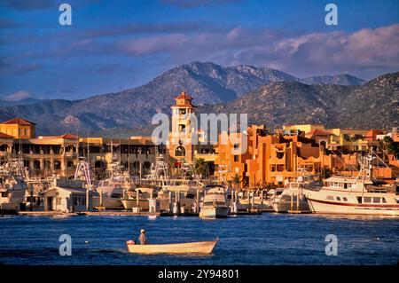 Hotels over harbor, fisherman in boat, at Cabo San Lucas, Baja California Sur, Mexico Stock Photo