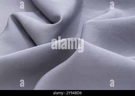 Soft gray fabric with smooth folds, creating a versatile background and texture for interior design and fashion concepts Stock Photo