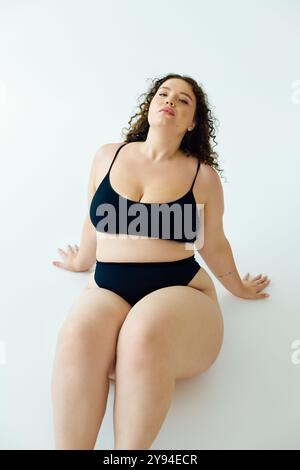 The plus size woman, seated gracefully, showcases confidence and beauty