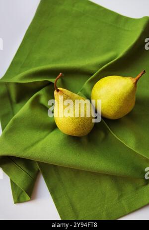 two ripe pear lies on a green napkin. Stock Photo