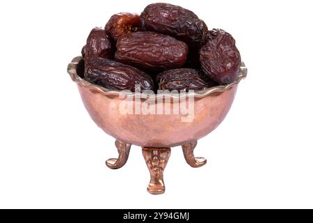 A bowl of fresh, plump Medjool dates in a vintage copper bowl with intricate detailing Stock Photo
