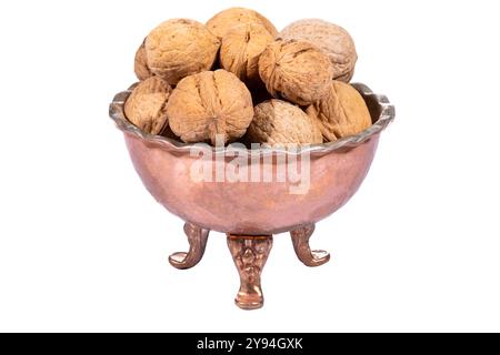 Whole walnuts displayed in a handcrafted copper bowl, highlighting natural textures and rich, earthy tones Stock Photo