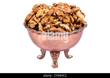 Freshly shelled walnut halves in a vintage copper bowl with a rustic look, isolated on white background Stock Photo