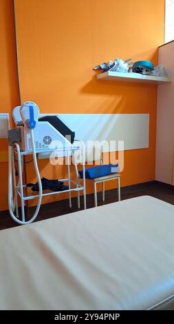 Modern medical examination room with equipment and bright orange walls Stock Photo