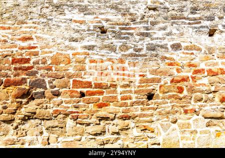 Ancient weathered rough stone wall as creative background. Grunge brick wall texture background Stock Photo