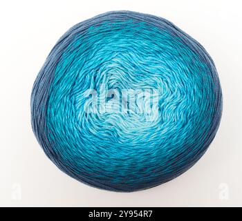 This image features a skein of yarn with a beautiful gradient of blue tones, ranging from dark navy to light aqua. The yarn is neatly wound into a cir Stock Photo