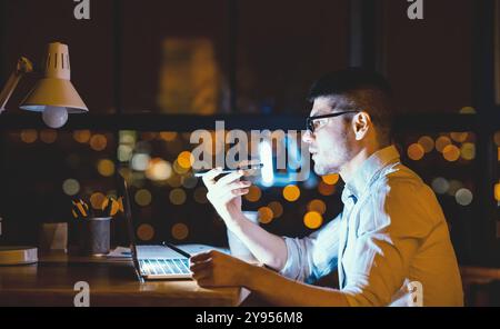 Serious Entrepreneur Using Loudspeaker Talking On Cellphone In Modern Office Stock Photo
