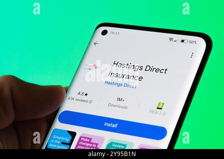 Hastings Direct Insurance app displaying on mobile phone with customer reviews, installation option, and latest features. Focus on mobile insurance ma Stock Photo