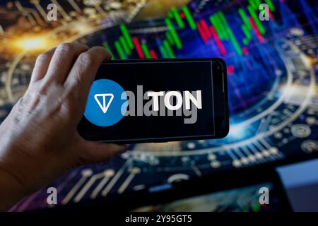 London, London, UK. 8th Oct, 2024. In this photo illustration, the TON logo is seen displayed on a smartphone screen against a computer screen displaying a stock market graphs and virtual reality illustration. (Credit Image: © Dominika Zarzycka/SOPA Images via ZUMA Press Wire) EDITORIAL USAGE ONLY! Not for Commercial USAGE! Stock Photo