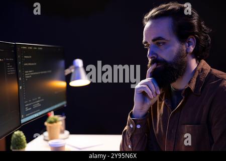 Pensive programmer thinking how to design and develop software applications. Contemplative IT professional brainstorming ways of implementing and maintaining company systems Stock Photo