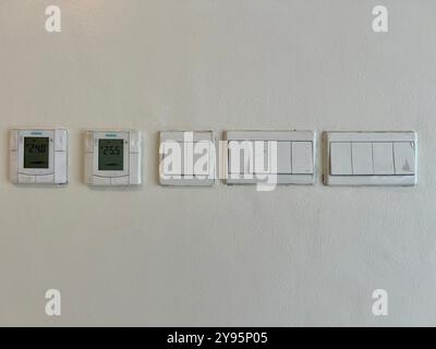 Depok, August 26 - 2024. White electrical switch for air conditioner and light mounted on white wall Stock Photo