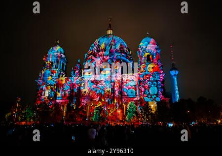 Berlin, Germany - October 6, 2024: Crowd of people enjoy the illumination show on the facade of famous Berlin Cathedral (Berliner Dom) during annual Festival of Lights in Berlin Stock Photo