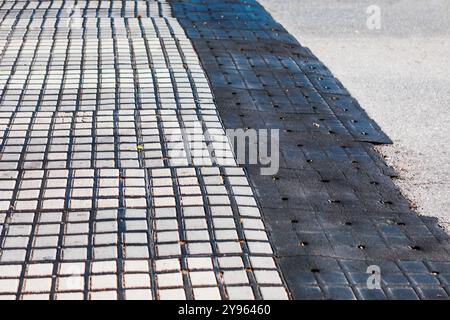 Paving black tiles on the ground in the city. Abstract street background.  Black and white tiled sidewalk featuring a geometric pattern Stock Photo