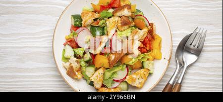 Traditional Levant dish Fattoush salad, Arab cuisine, with pita bread croutons, vegetables, herbs. Healthy Middle Eastern vegetarian salad, rustic woo Stock Photo
