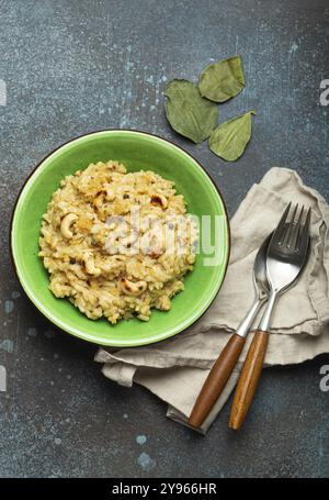 Ven Pongal (Khara Pongal), traditional Indian savoury rice dish made during celebrating Pongal festival, served in bowl top view on concrete rustic ba Stock Photo