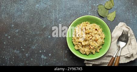 Ven Pongal (Khara Pongal), traditional Indian savoury rice dish made during celebrating Pongal festival, served in bowl top view on concrete rustic ba Stock Photo