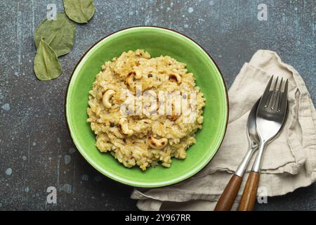 Ven Pongal (Khara Pongal), traditional Indian savoury rice dish made during celebrating Pongal festival, served in bowl top view on concrete rustic ba Stock Photo